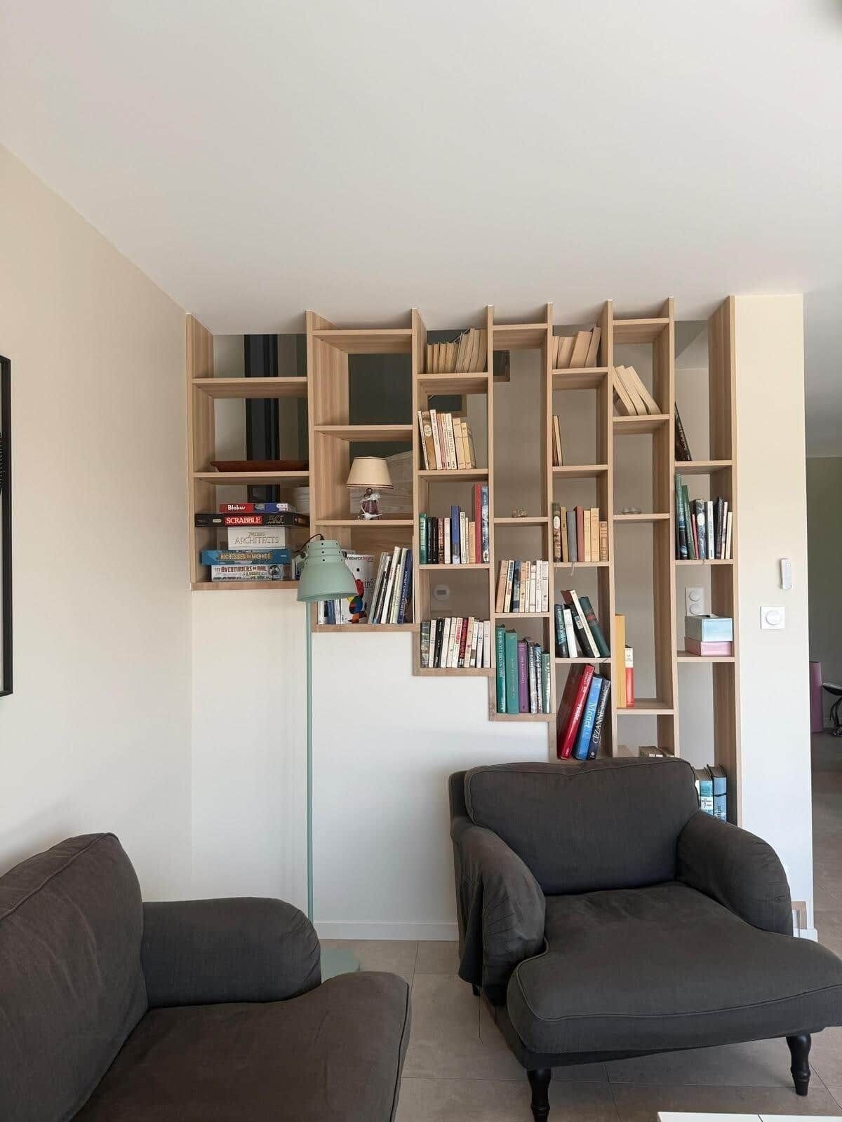 A living room with two sofas, a bookshelf, and a lamp.