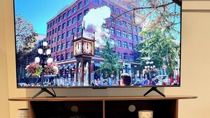 Un televisor sobre un soporte de madera con libros y objetos decorativos.
