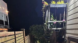 Un sendero estrecho que lleva a una cerca de madera y un edificio con una ventana.