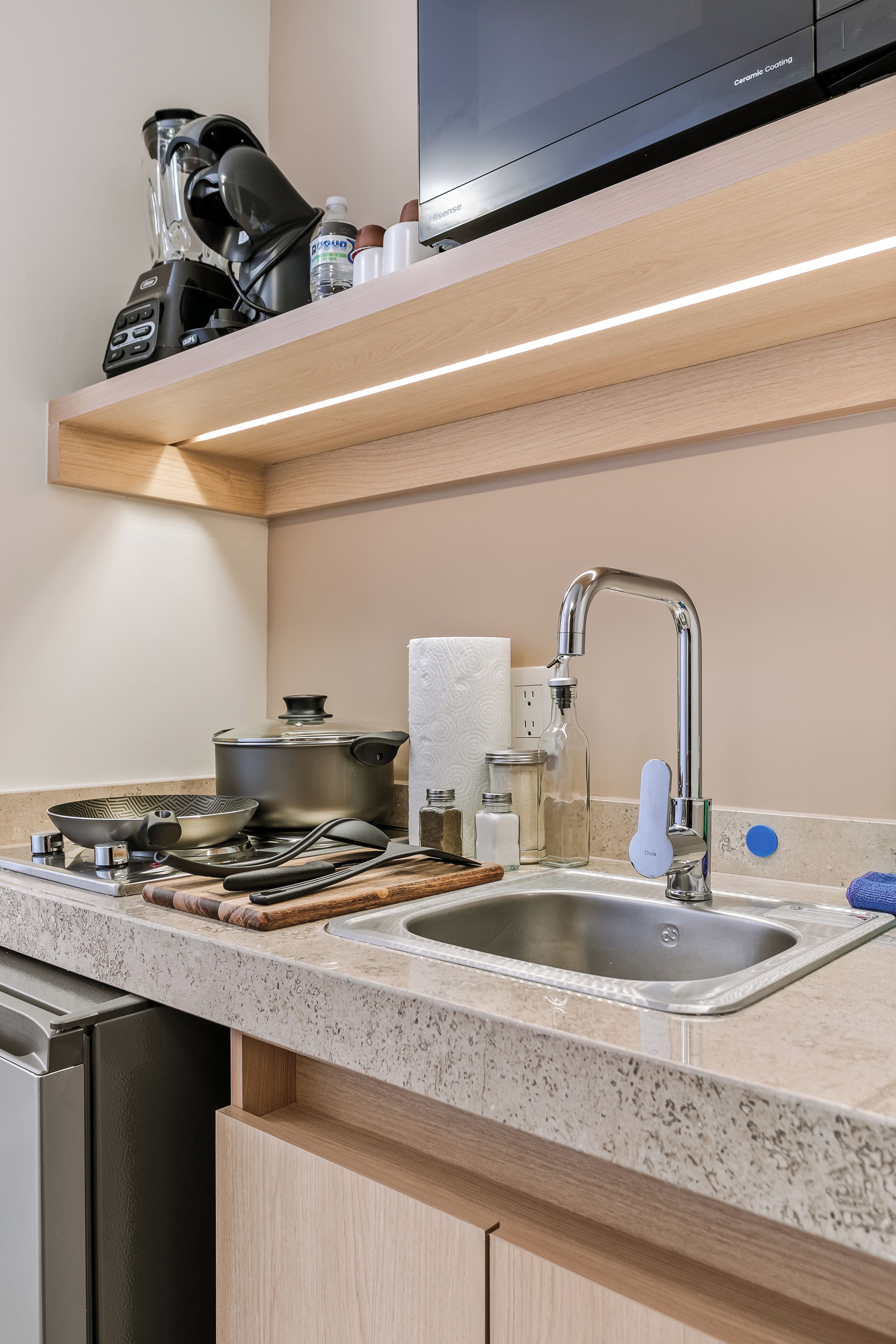 Een moderne keuken met een dubbele spoelbak, roestvrijstalen apparatuur en een houten aanrecht.