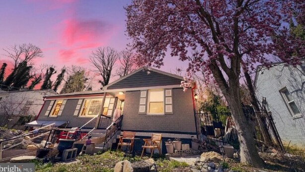 A two-story house with a front porch, a staircase, and a tree with pink blossoms. - cozy house near Washington D.C (Temple Hills)