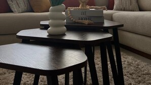 A living room with a sofa, a coffee table, and a vase with flowers. - Very nice apartment for rent in kenitra with swimming pool and gym (Kénitra)