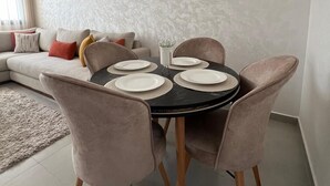 A dining area with a round table set for four, surrounded by four chairs. - Very nice apartment for rent in kenitra with swimming pool and gym (Kénitra)