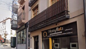 A building with a storefront labeled "Homyflat.es" and a sign for "Plataforma Inmobiliaria Digital".