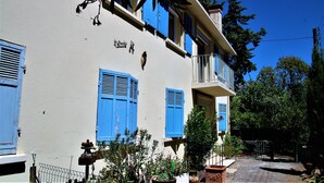 A building with blue shutters, a balcony, and a sign that reads "Le Chapeau de Poche". - 3bedroom apartment, private garden, free parking, EV charger, AC, wifi, quiet. (Toulon)