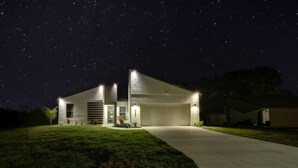 A modern house at night with a clear view of the sky.