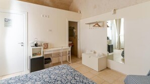 A compact bedroom with a bed, a small desk, a wardrobe, and a mirror. - Residenza Già Antico Forno (Matera)