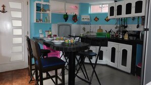 A kitchen with a dining table, chairs, and various kitchen appliances and utensils. - Central Department in Baños (Baños de Agua Santa)