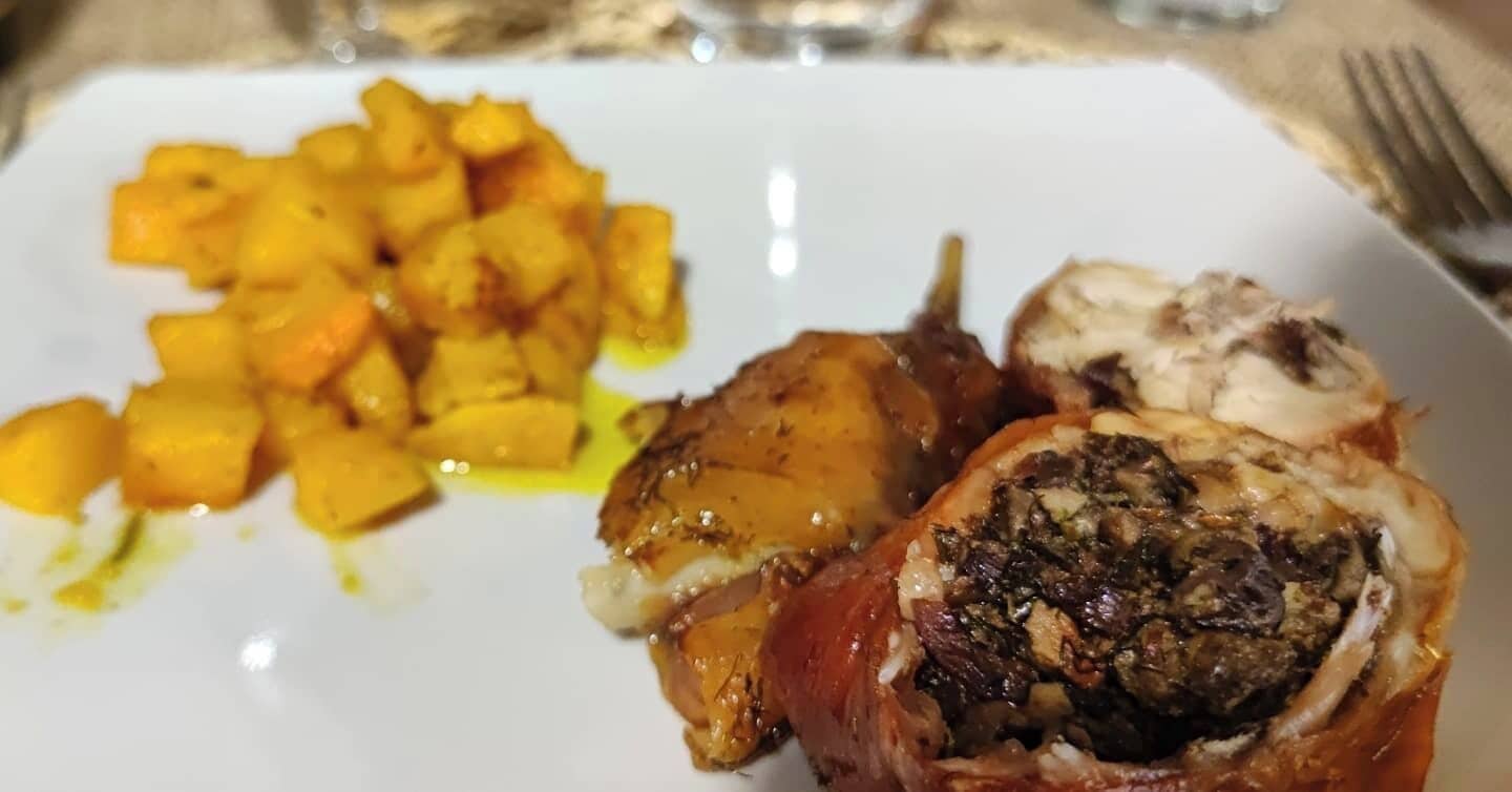 A plate with a stuffed chicken breast and roasted potatoes.