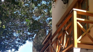 Un bâtiment doté d’une façade en pierre, d’un balcon en bois et de grandes fenêtres.