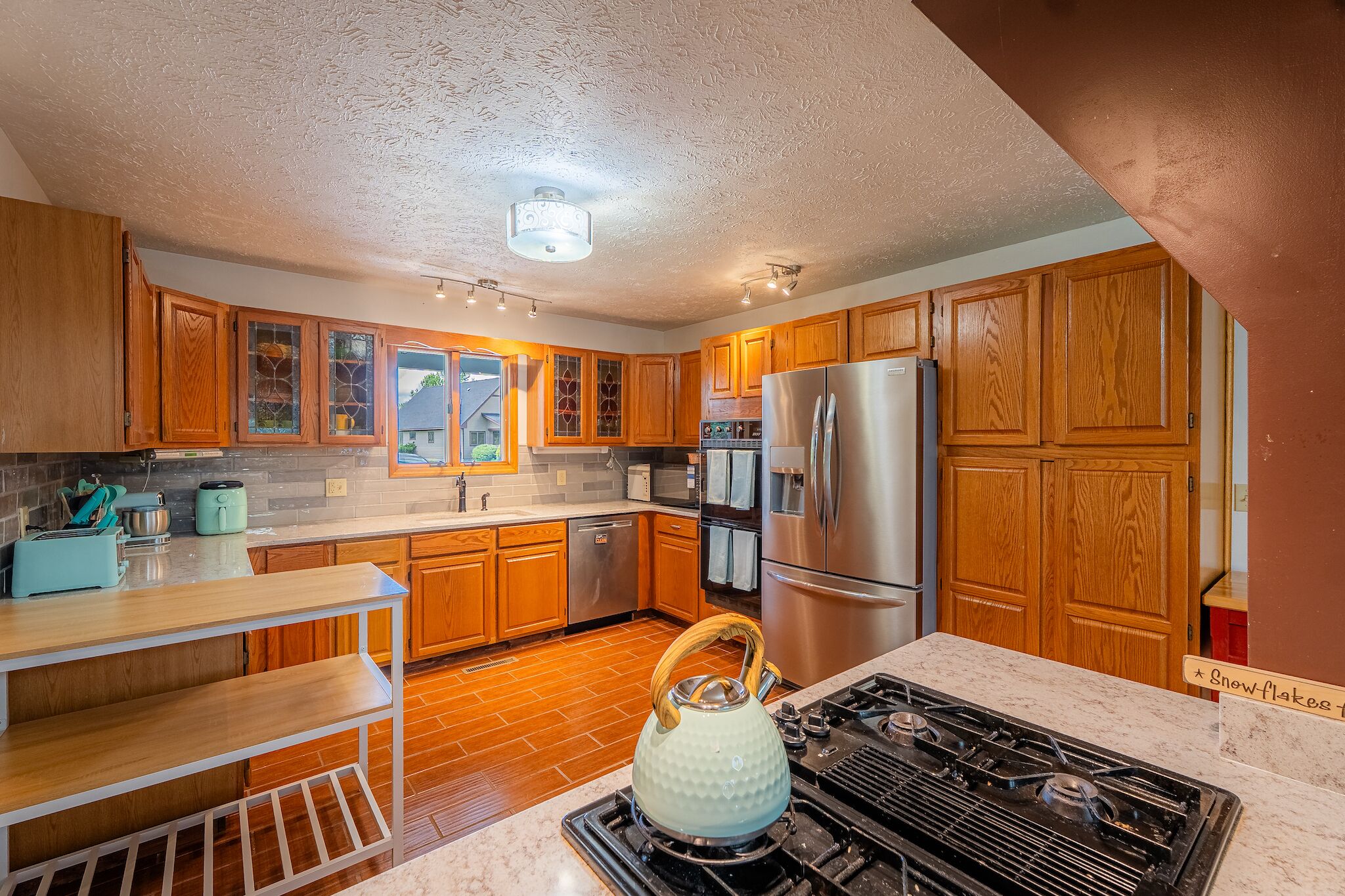 A kitchen with wooden cabinets, stainless steel appliances, and a gas stove.