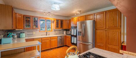 A kitchen with wooden cabinets, stainless steel appliances, and a gas stove.