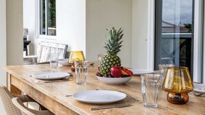 Et spisebord med tallerkener, bestik, glas og en skål med frugt.