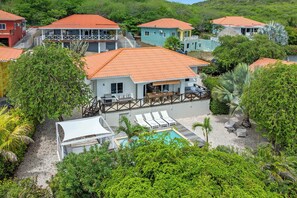 Bairro residencial com várias casas, uma piscina e um espaço coberto com varanda.