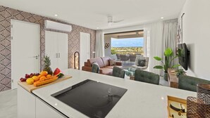 A modern kitchen with a Bosch induction cooktop, a fruit bowl, and a white countertop. - Palm Paradise-Stylish Island Live-Blue Bay Curaçao (Willemstad)