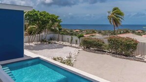 Une piscine offrant une vue sur l’océan et le paysage environnant.