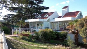 A modern two-story house with a covered patio and a swimming pool. - HOTEL CRISTAL (Villa Carlos Paz)
