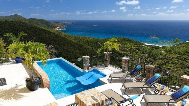A rooftop pool with blue loungers and a view of the ocean. - South Shore Villa, SolVillasUSVI (Cruz Bay)