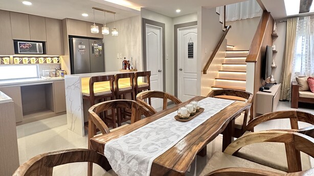A modern kitchen with a built-in microwave, refrigerator, and dining area with wooden chairs and a marble table. - 4-bedroom house in enchanting San Fernando with WiFi, AC (San Fernando)