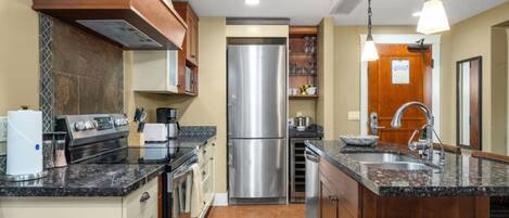 Een koelkast, een broodrooster, kookgerei, borden en bestek, eettafels