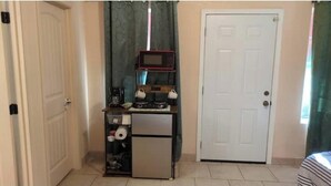 A compact kitchen with a microwave, refrigerator, and a small countertop. - Beautiful private room, garden! (Yuma)