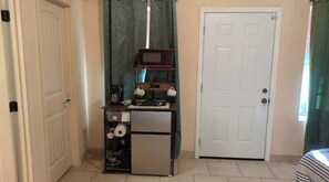 A compact kitchen with a microwave, refrigerator, and a small countertop. - Beautiful private room, garden! (Yuma)