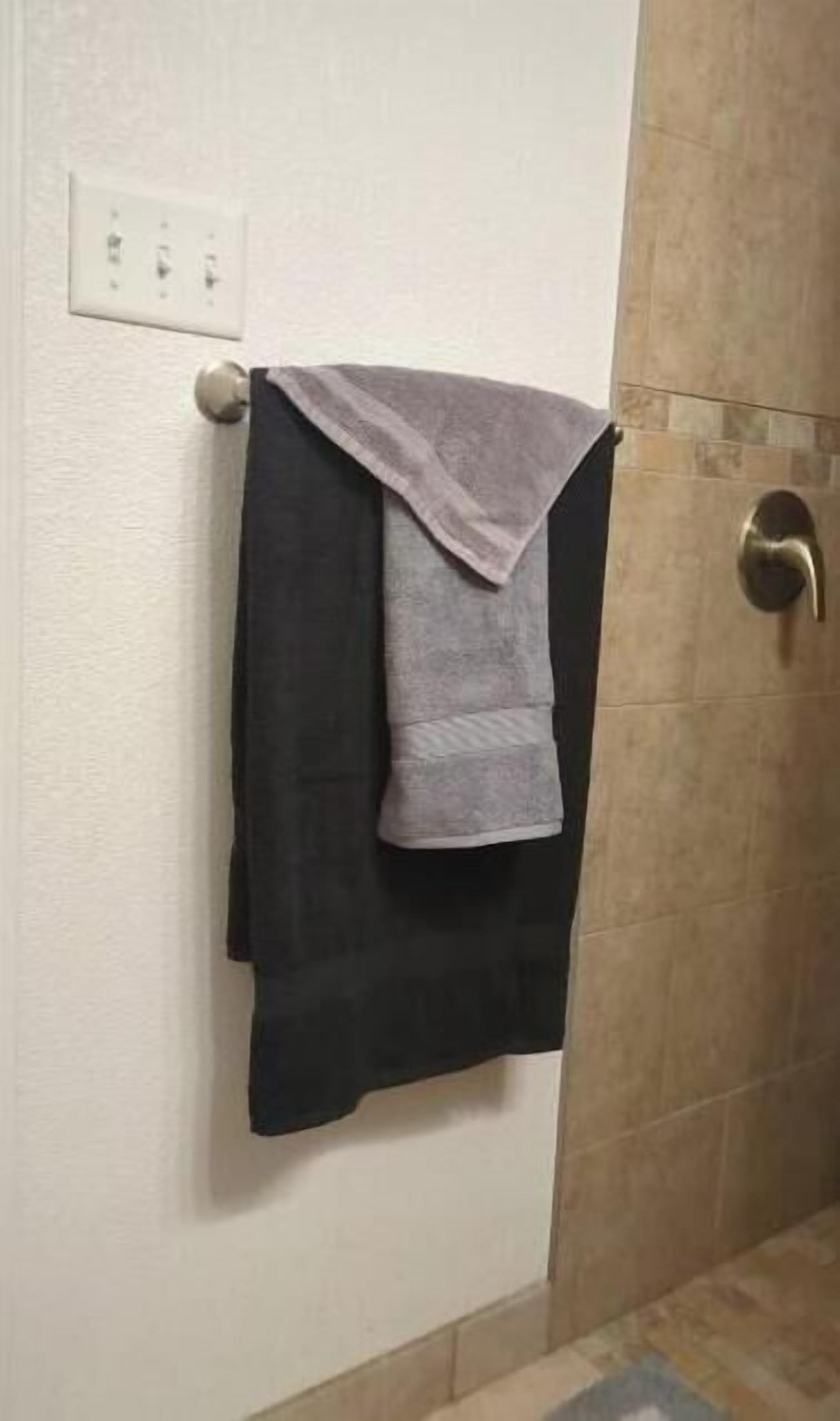 Een douche, handdoeken, zeep, toiletpapier