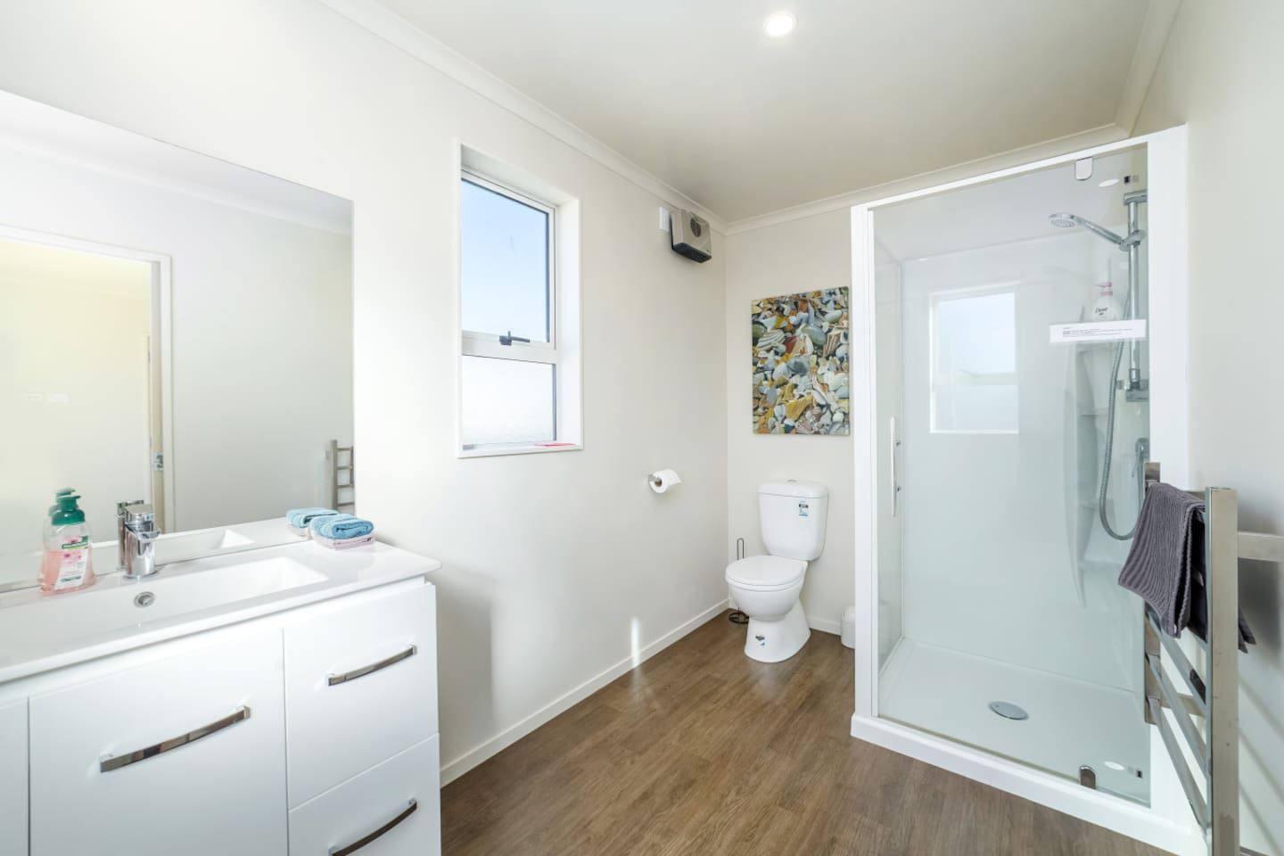 A modern bathroom with a shower, toilet, and sink.