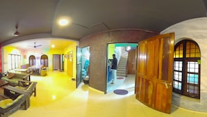 Una habitación amplia con un ventanal grande, un sofá, una silla y una mesa.