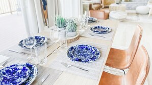 A dining table set with blue patterned plates, clear glasses, and a white placemat.