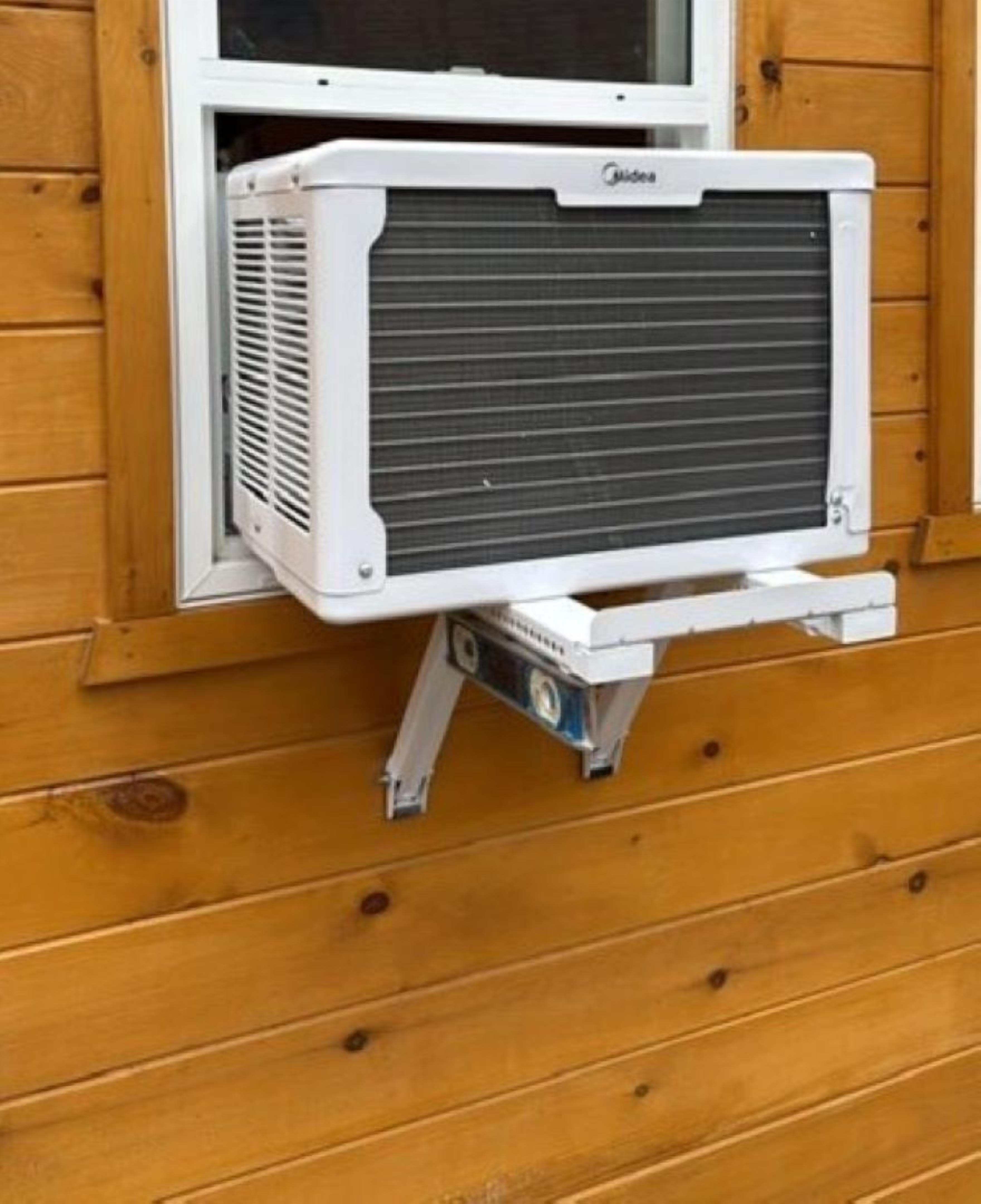 Eine Klimaanlage an einer Holzwand befestigt.