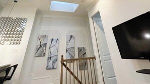 Un intérieur moderne agrémenté de lucarnes, d’un éclairage encastré et d’un téléviseur à écran plat.