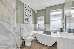 A modern bathroom with a freestanding bathtub, a toilet, and a glass shower enclosure. - Hove Alone 5 Top Floor By My Getaways (Hove)