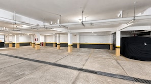 Een ruime parkeergarage met meerdere verdiepingen, betonvloeren en een centrale afvoergat.