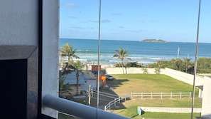A view of the ocean from a balcony with a railing, a grassy area, and a white fence. - Aguas de Marco  (Florianopolis)