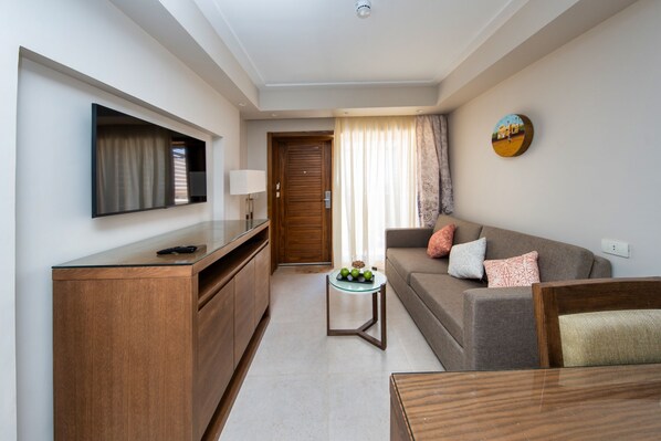 A modern living room with a sofa, a coffee table, and a TV mounted on the wall. - Retac Abu Simbel (Abu Simbel)