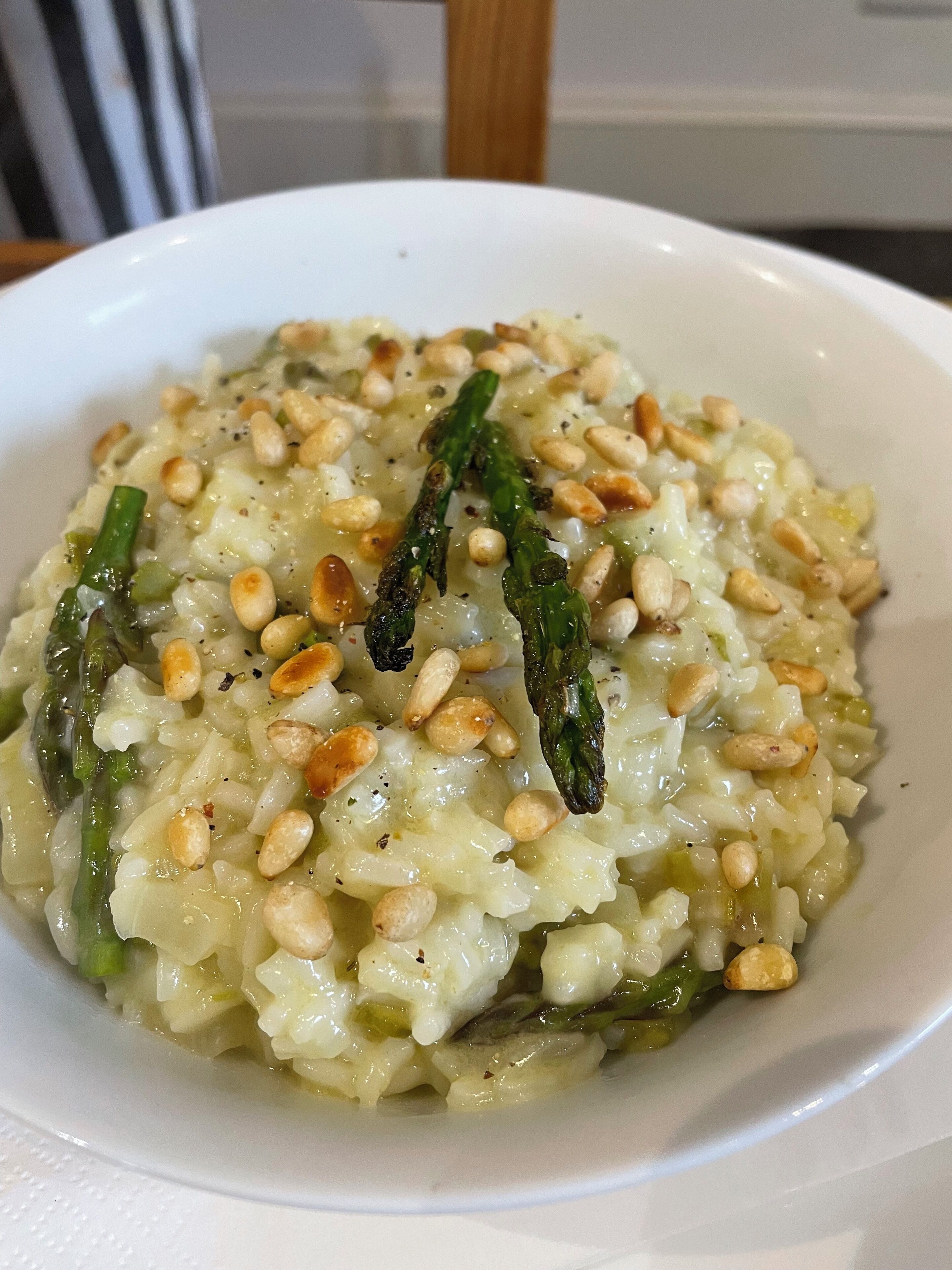 A plate of risotto with asparagus and pine nuts.