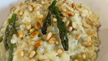 A plate of risotto with asparagus and pine nuts.