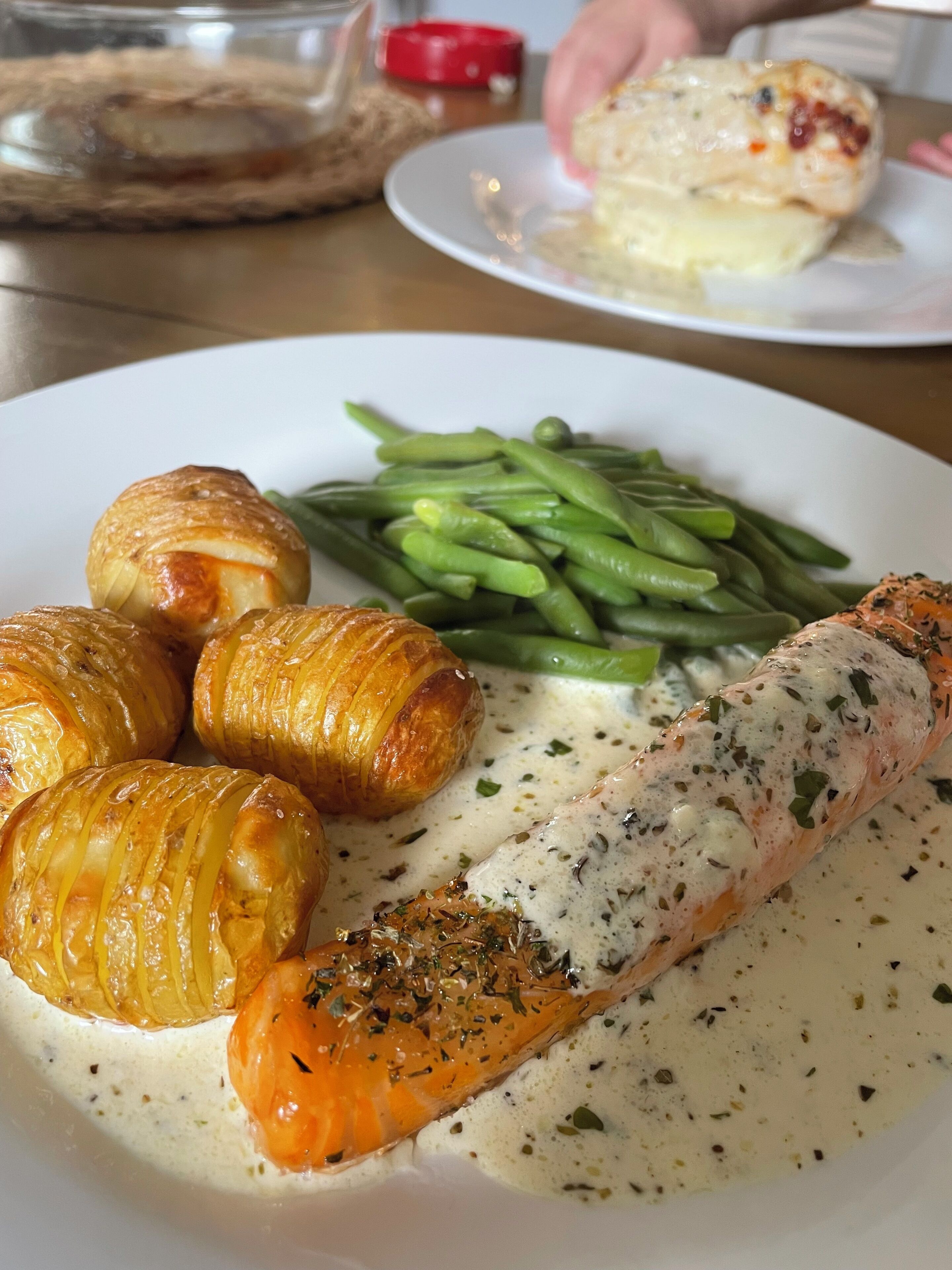 A plate with salmon, green beans, and croissants.