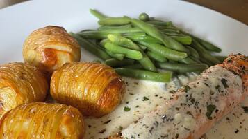 A plate with salmon, green beans, and croissants.