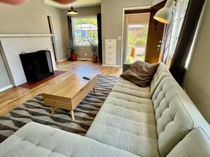 Una sala de estar moderna con un sofá, una mesa de centro y un mueble para televisión.