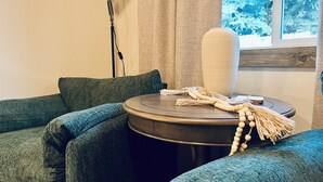 Une pièce chaleureuse avec une table de massage, un grand coussin blanc et une guirlande de perles.