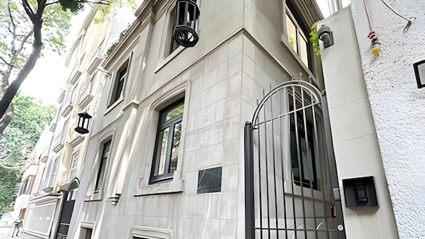 A building with a large entrance gate, multiple windows, and a paved sidewalk. - Modern Suite 3 - Heart of Roma Norte (Mexico City)