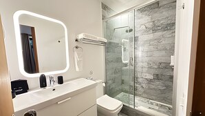 A modern bathroom with a glass shower, a white sink, and a large mirror. - Modern Suite 3 - Heart of Roma Norte (Mexico City)