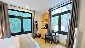 A hotel room with a bed, a chair, a small table, and a wardrobe. - Modern Suite 3 - Heart of Roma Norte (Mexico City)