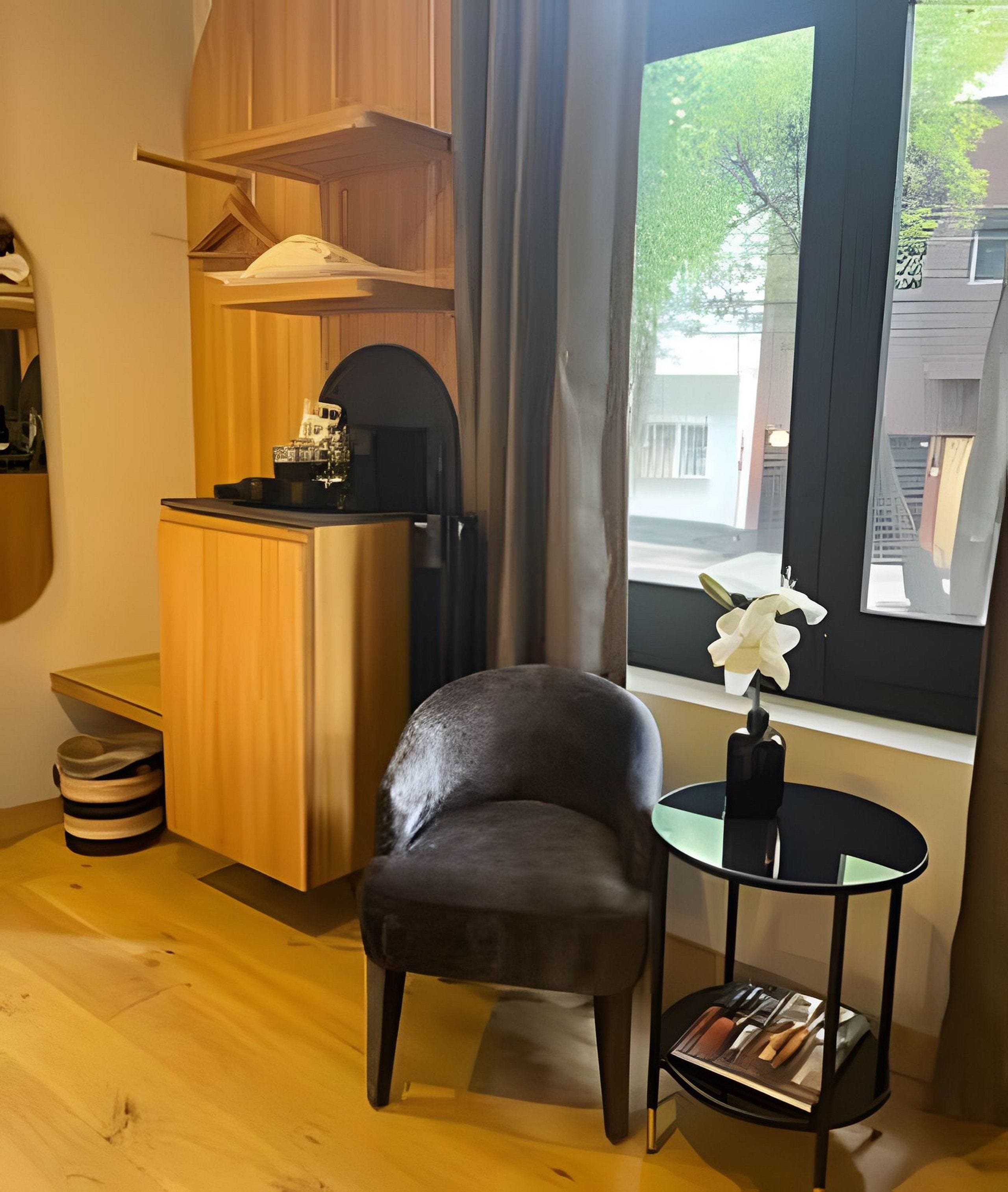 A compact room with a wooden cabinet, a small round table with a vase, and a chair.