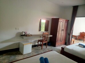 A hotel room with a bed, a desk, a chair, a wardrobe, and a small table. - Siem Reap Local Stay (Siem Reap)