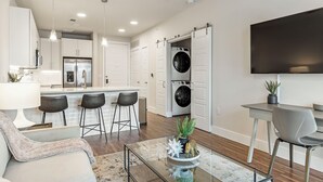 A modern kitchen with white cabinets, a built-in oven, and a stainless steel refrigerator. - Landing Apartments near UT San Antonio (San Antonio)