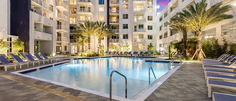 Una piscina al aire libre, sillones reclinables de piscina