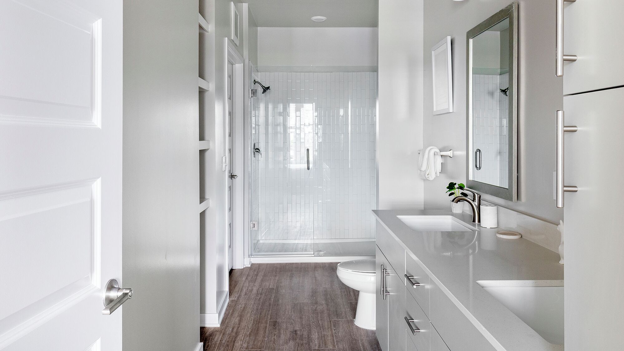 A modern bathroom with a shower, toilet, and sink.